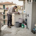 Tecnico che controlla un balcone con armadio da esterno e carichi domestici distribuiti vicino al bordo